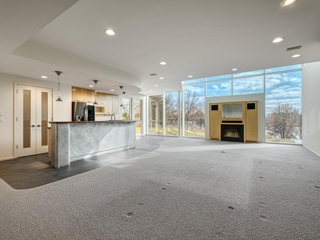 Expansive walkout lower-level showcasing walls of glass and serene views