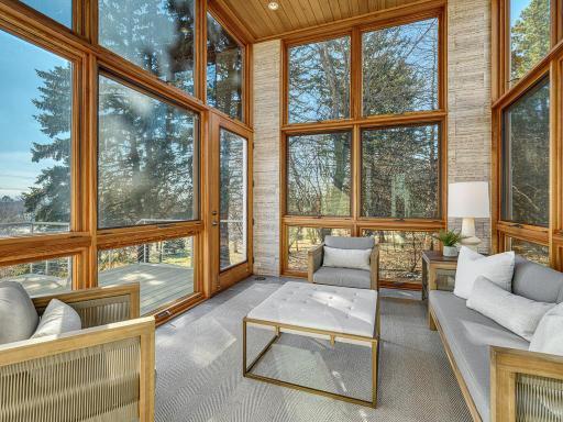 Unwind in the bright and airy sunroom framed by expansive floor-to-ceiling windows