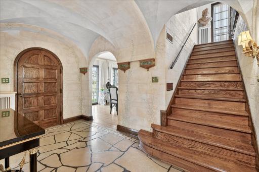 Large entryway with limestone tiled floors, vaulted arches, and hand painted plaster walls.