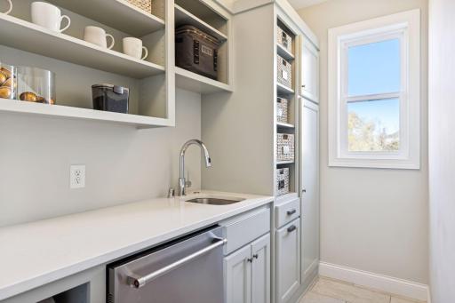 This thoughtfully designed Butlerâs Pantry serves as a functional prep kitchen. Custom cabinetry, quartz countertops, electrical outlets for small appliances, open shelving & a 2nd dishwasher.