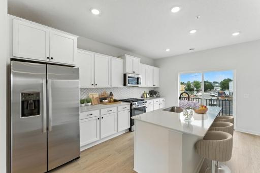 Light and bright! The kitchen has timeless finishes that blend an elevated feel with functionality. Similar home shown. Color and finish can vary.