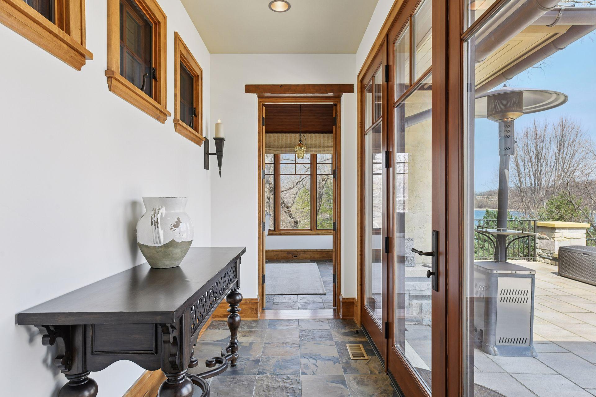 Step down the hallway to the sunroom with walk-out access to the pool area