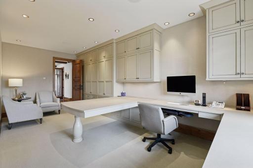 Main floor office #2 with built-in desk and cabinets; conforming bedroom space