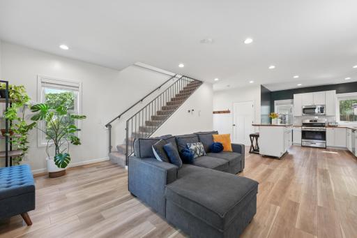 Warm natural-toned flooring, elevated ceilings, and recessed lighting add style and sophistication throughout the home