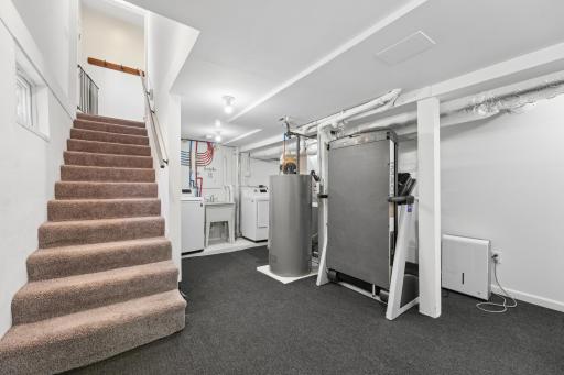The lower-level includes a fourth bedroom, bathroom, and laundry area, ideal for guests, family, or additional living needs