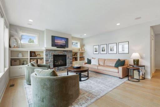 20. Sunlit and spacious, with hardwood floors, custom built-ins, and a dramatic stone fireplace that anchors the space.jpg