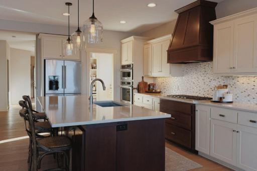26. Gourmet Kitchen_ Quartz counters, stainless-steel appliances, and an expansive walk-in pantry make this kitchen both functional and beautiful.jpg