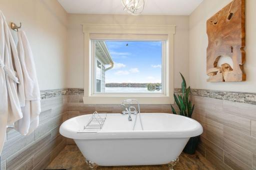 50. Private suite with spa-inspired bath, soaking tub, walk-in shower, and large windows framing serene lake views.jpg