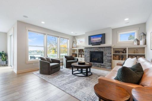 19. Sunlit and spacious, with hardwood floors, custom built-ins, and a dramatic stone fireplace that anchors the space.jpg