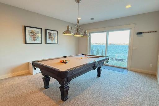 35. Lower-Level Walk-Out_ Entertain effortlessly in the finished lower level, featuring a full bar, cozy fireplace, and direct access to the lakeside patio.jpg