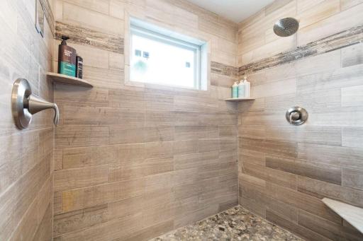 51. Private suite with spa-inspired bath, soaking tub, walk-in shower, and large windows framing serene lake views.jpg