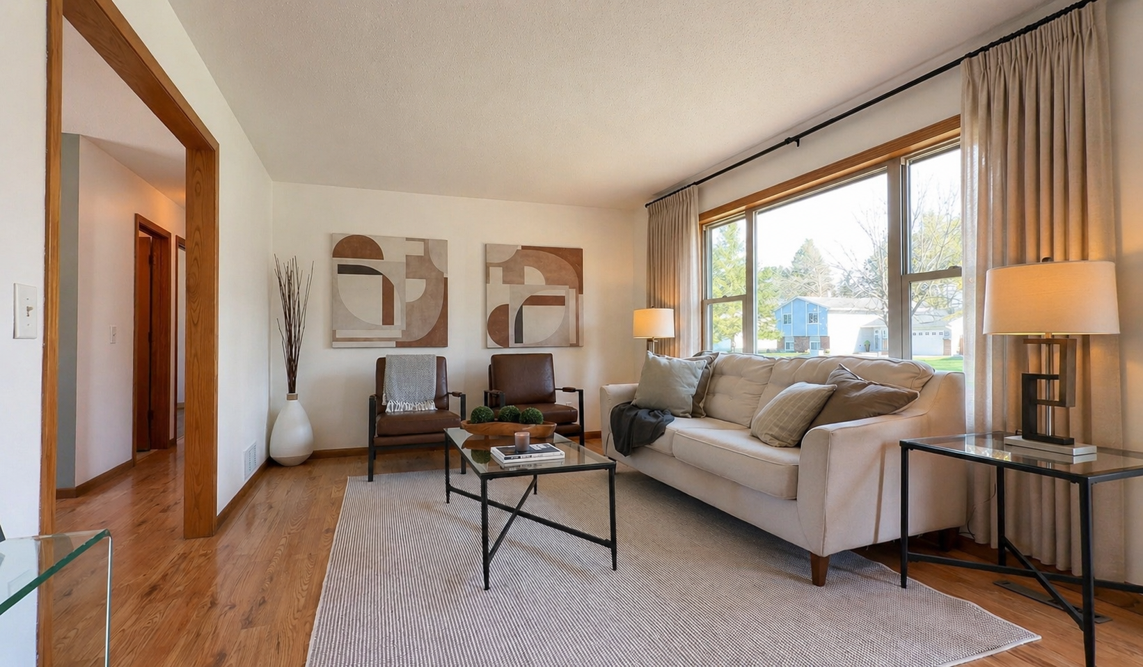 Natural light pours through oversized windows, casting a warm glow across newly refreshed surfaces and layered textures. Enjoy both slow mornings and lively evenings—grounded by warm wood tones and a palette that feels effortlessly modern.