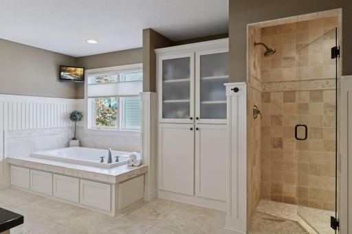 Jacuzzi tub, built in storage with large walk in shower with bench