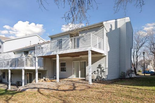 Enjoy two levels of outdoor space with an upper deck and walk-out patio, both overlooking open green space.