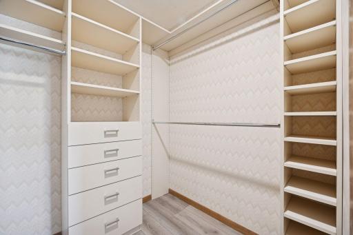 Custom-built shelving and drawers provide excellent storage and organization in the primary suite.