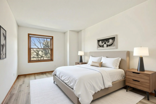 Spacious primary bedroom with fresh flooring, large window and neutral tones ready for your personal touch.