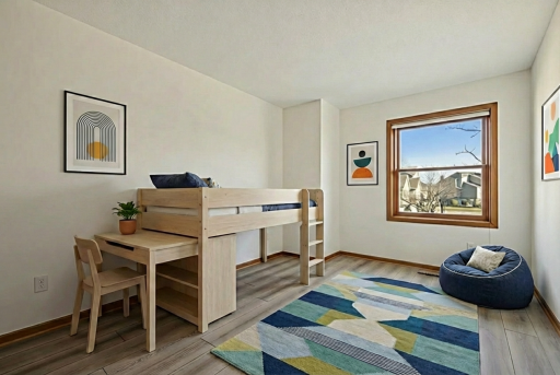 Bright second bedroom with a large window and modern flooring, perfect for a guest room or home office. Virtually staged.