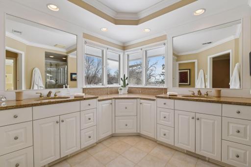 Remodeled primary bathroom with comfort-height cabinets and his and her vanities. So much storage!