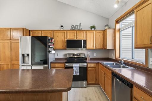 Spacious kitchen featuring Updated stainless steel appliances, abundant cabinetry, center island, and vaulted ceiling for an airy feel.