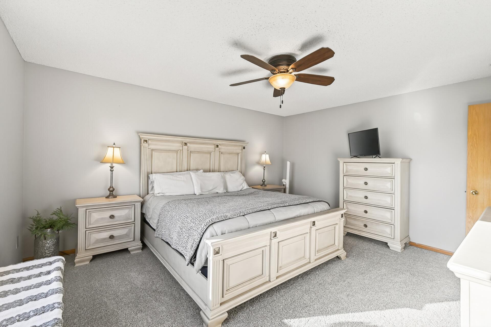 Generous bedroom layout with room for a full furniture set and soft, neutral finishes.