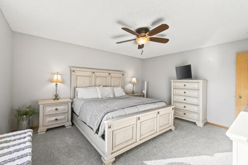 Generous bedroom layout with room for a full furniture set and soft, neutral finishes.