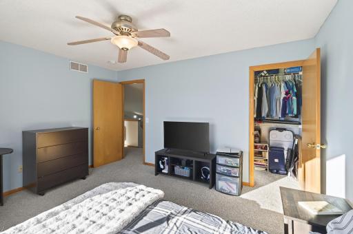 Additional bedroom with large closet, ceiling fan, and easy access to the upper-level hallway.