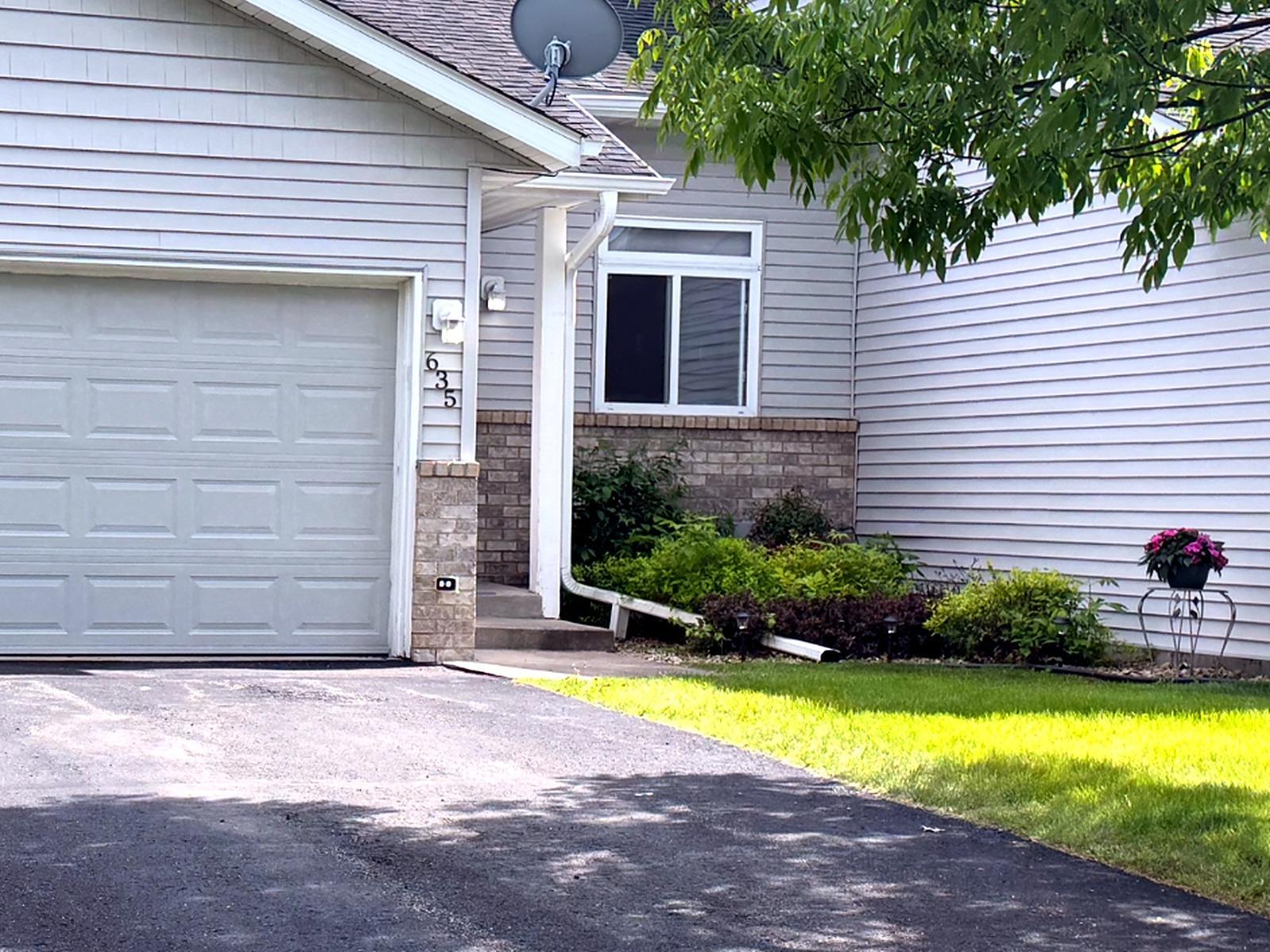 Front view showcasing the two-car garage, driveway, updated exterior appeal, and landscaped entry.