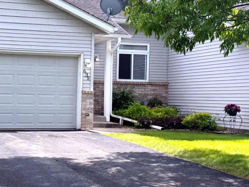 Front view showcasing the two-car garage, driveway, updated exterior appeal, and landscaped entry.