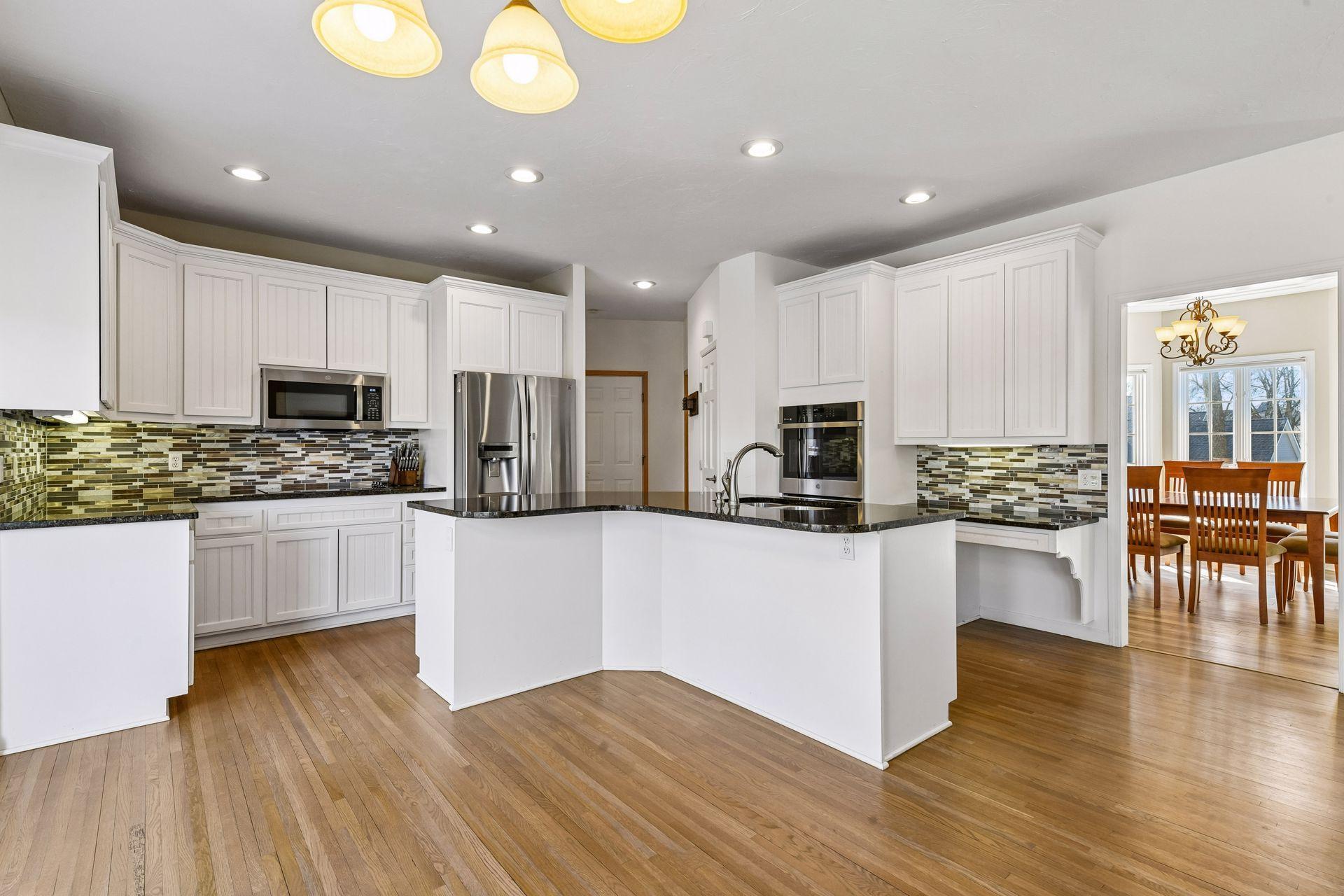 The Sun-drenched kitchen has stainless steel appliances and gleaming hardwood floors. It serves as the heart of the home, offering easy access to both formal and informal dining areas!
