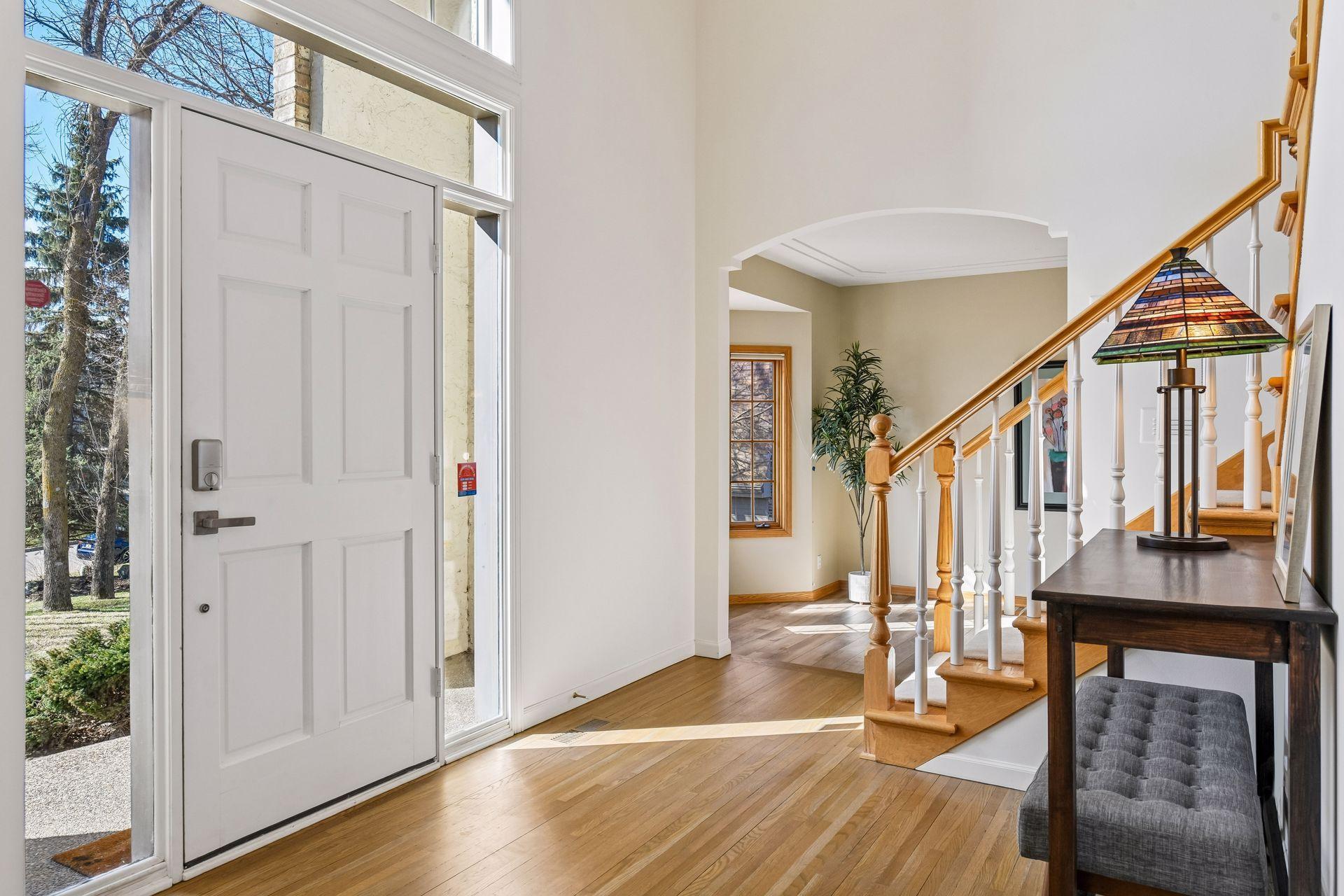 Step into a grand two-story foyer featuring a striking curved archway that leads to the living areas. The open design and elegant staircase create a seamless, sophisticated flow.