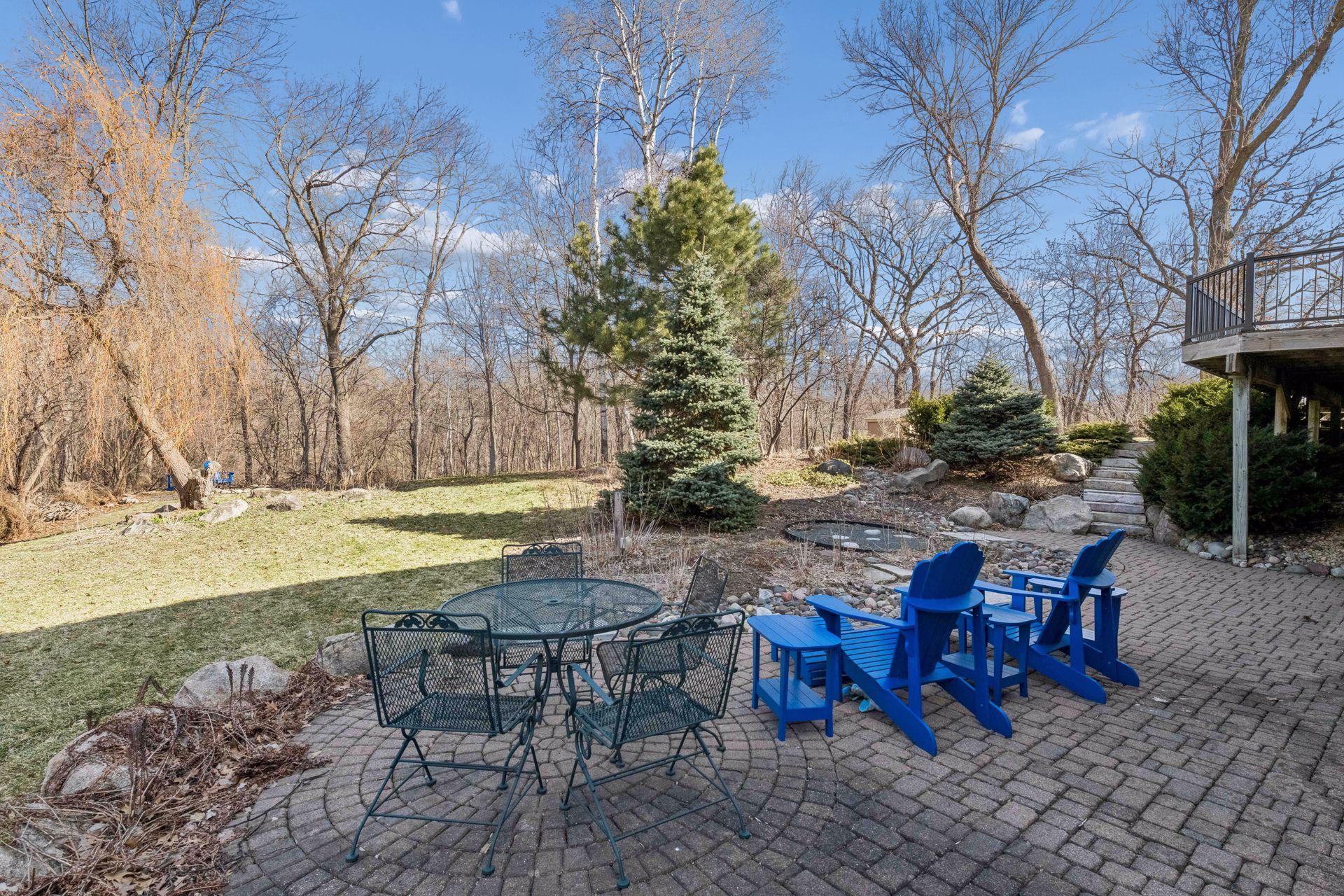 Charming lower-level paver patio perfect for shaded relaxation. This tiered outdoor space offers easy access to the lush, wooded backyard!