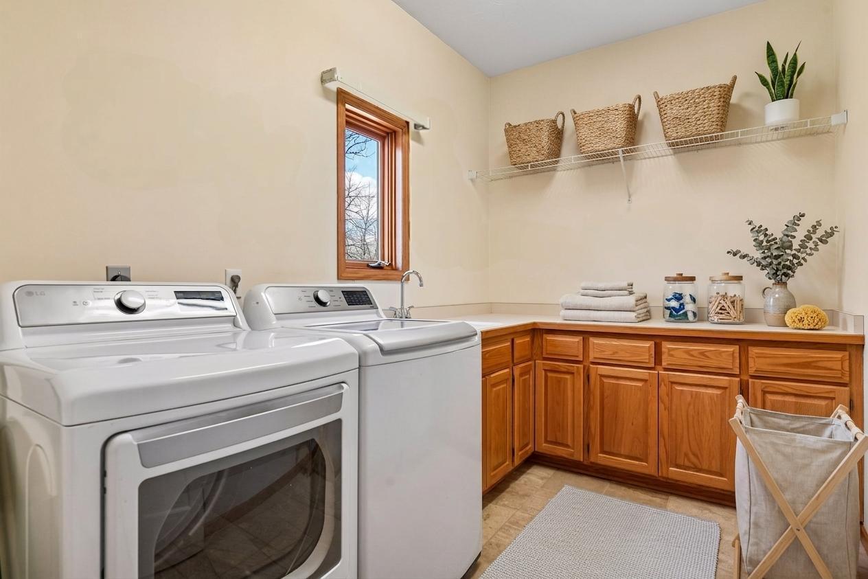 The spacious main floor laundry room features a convenient utility sink, ample cabinetry, and generous counter space for folding! *Virtually staged to show design options.