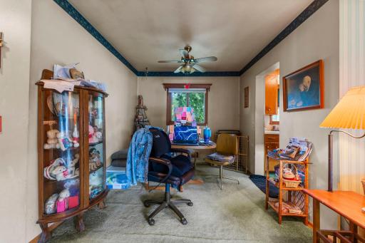The dining room features carpeting, a ceiling fan, and a window that fills the space with natural light.