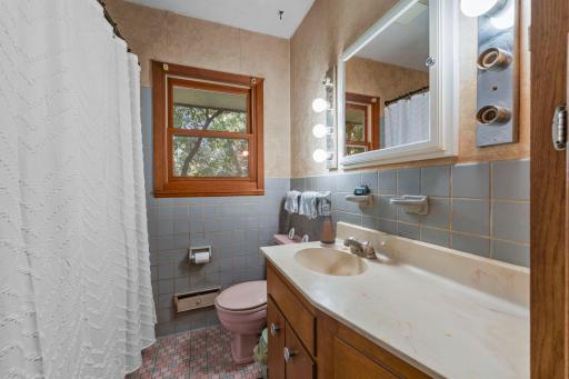 Just steps from both bedrooms is a full bathroom with tile flooring, a single vanity, and a tub/shower combo. A spacious hallway linen closet adds extra storage and convenience.