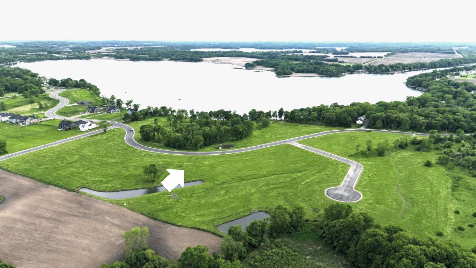 Lot 19 is a level lookout lot with a beautiful grove of trees and a pond to enjoy.