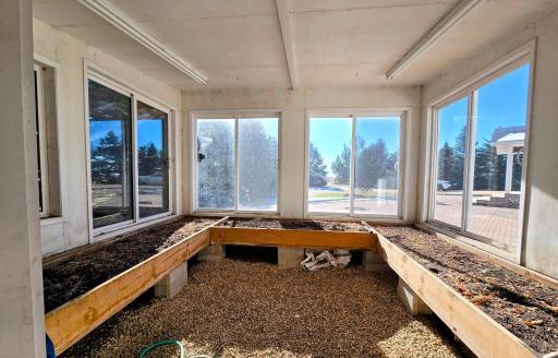 Raised garden beds in greenhouse with plenty of sunlight. If not used for greenhouse- building could have multiple uses.