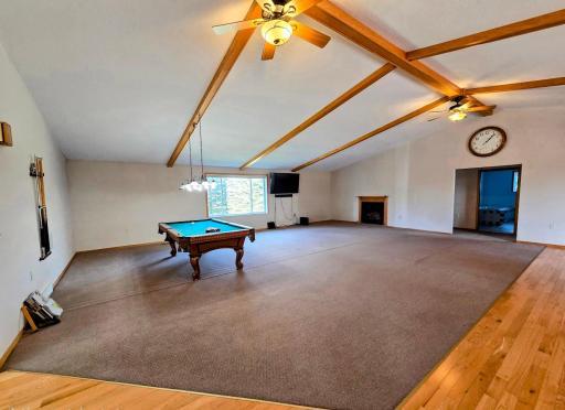 Carpeted living room with 2 ceiling fans.