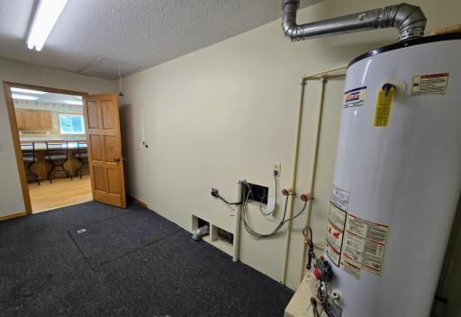 Utility room located off of the kitchen with door to crawl space & easy access to the washer & dryer plumbing