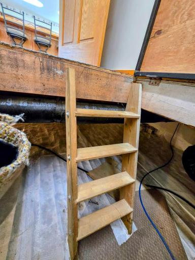 Lift up door on floor to short ladder to crawl space