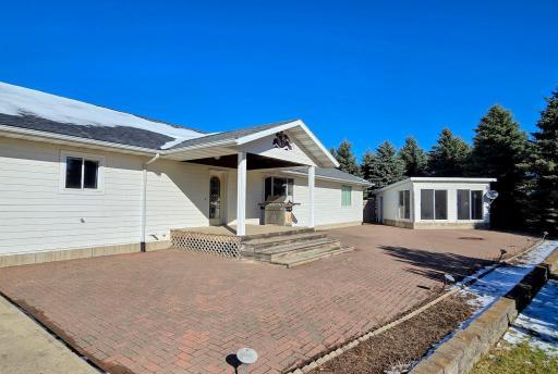 23 x 70 paver patio with landscaped with built up planters to add your favorite flowers or shrubs. Includes a built in firepit and covered front porch.