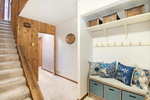 Step inside and you will find this foyer with a seating area. Access to the upper level is to the left.