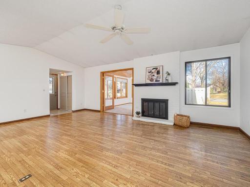 Welcome to 984 Yuma Ln N. The living room features a cozy fireplace and opens to the 4-season sunroom, filled with abundant natural light from large windows. Sunrooms are a sought-after feature that buyers love in these townhomes.
