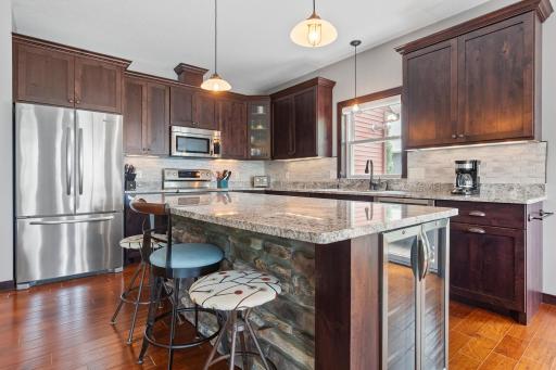 Kitchen includes stainless steel appliances, granite countertops and a convenient beverage cooler