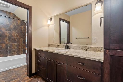 Upper level bathroom - granite countertops and pocket door to the shower room.