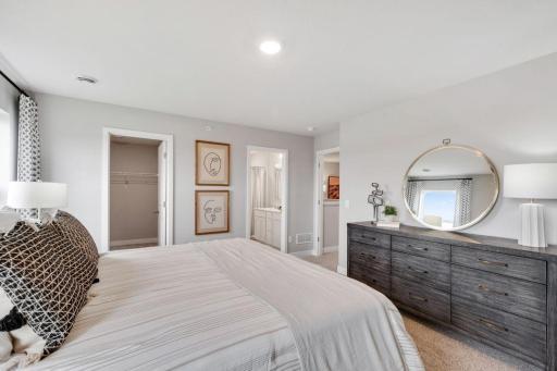 Private primary suite with room for a king size bed, dual vanities and oversized, walk-in closet. Photo is of model home. Colors and options may vary. Ask Sales Agent for details.