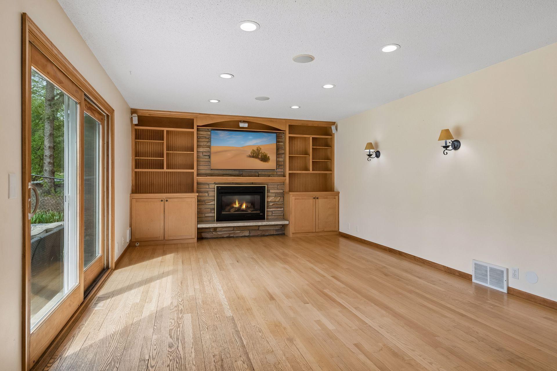 The inviting living room has an attractive, built-in shelving and cabinets for storage. A nice back-drop for the beautiful, stone-front, gas fireplace!