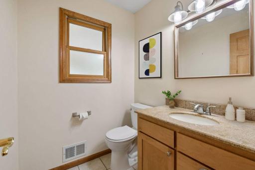 Your main floor powder room is conveniently located between the kitchen and the entry suite area of the home. Virtually Staged.