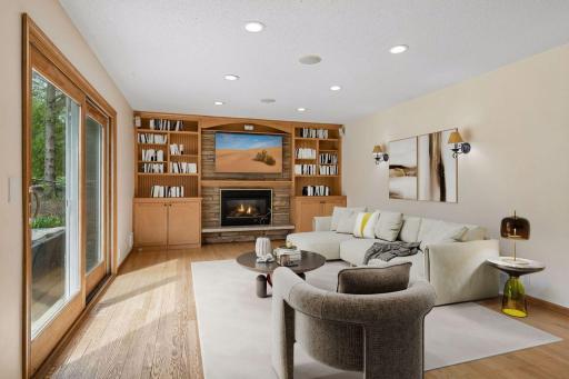 The inviting living room has an attractive, built-in shelving and cabinets for storage. A nice back-drop for the beautiful, stone-front, gas fireplace! Virtually Staged.