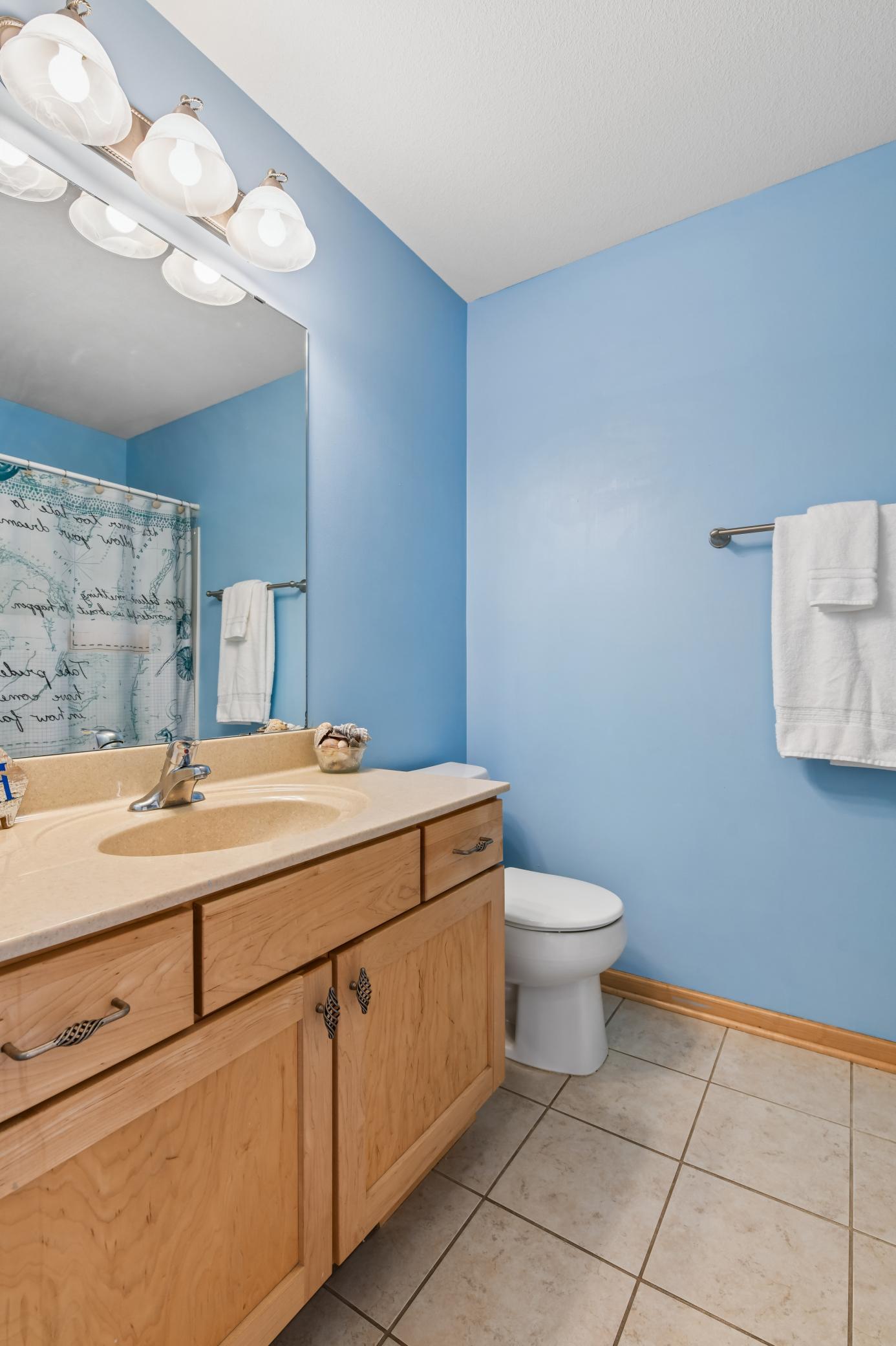 Full bath features tile floor, vanity offering storage and counter space, and fresh paint.