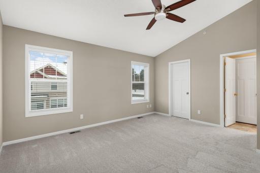 Spacious primary suite featuring vaulted ceilings, a generous walk-in closet and private full bathroom.